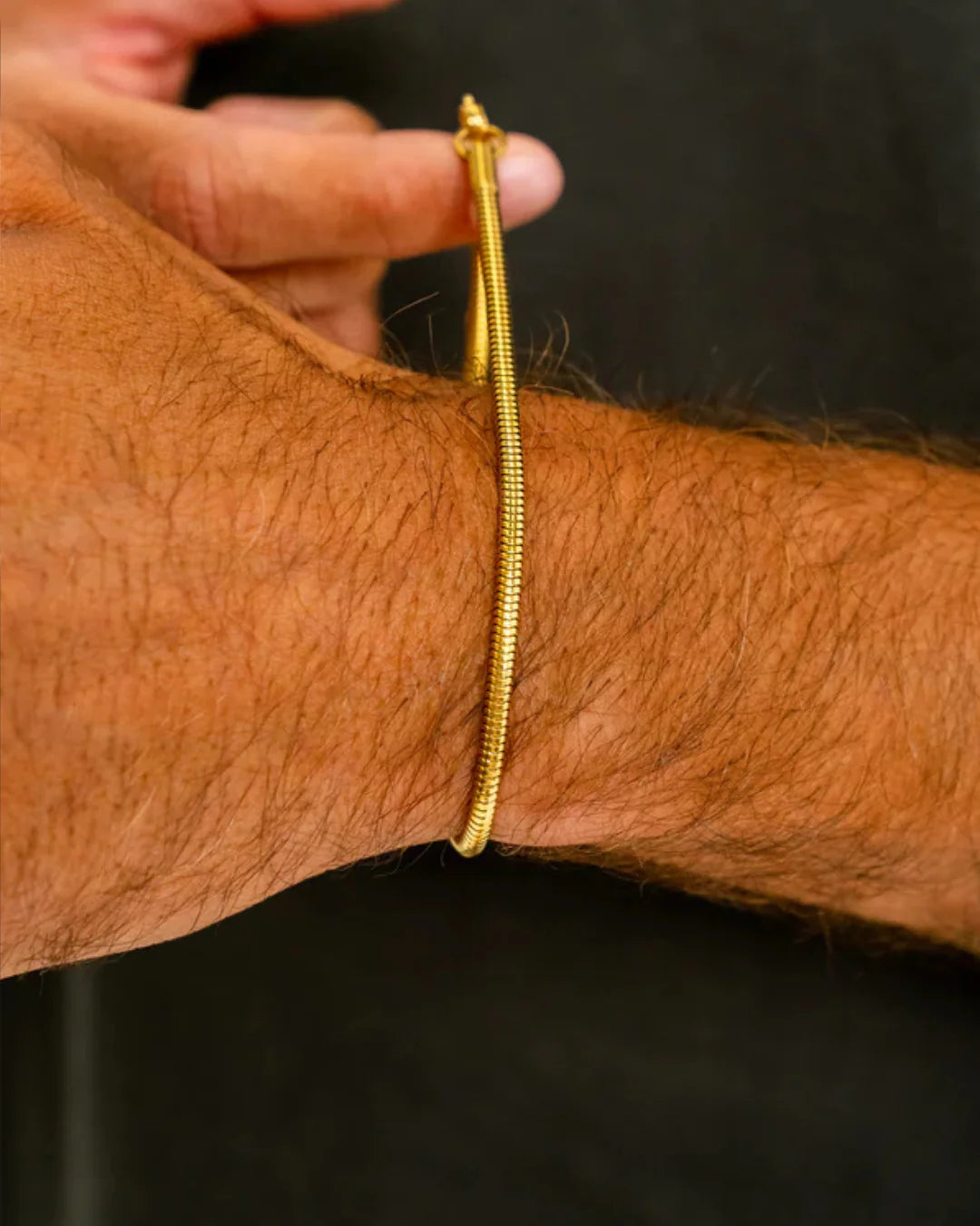 Gold bracelet on a wrist with a blurred background