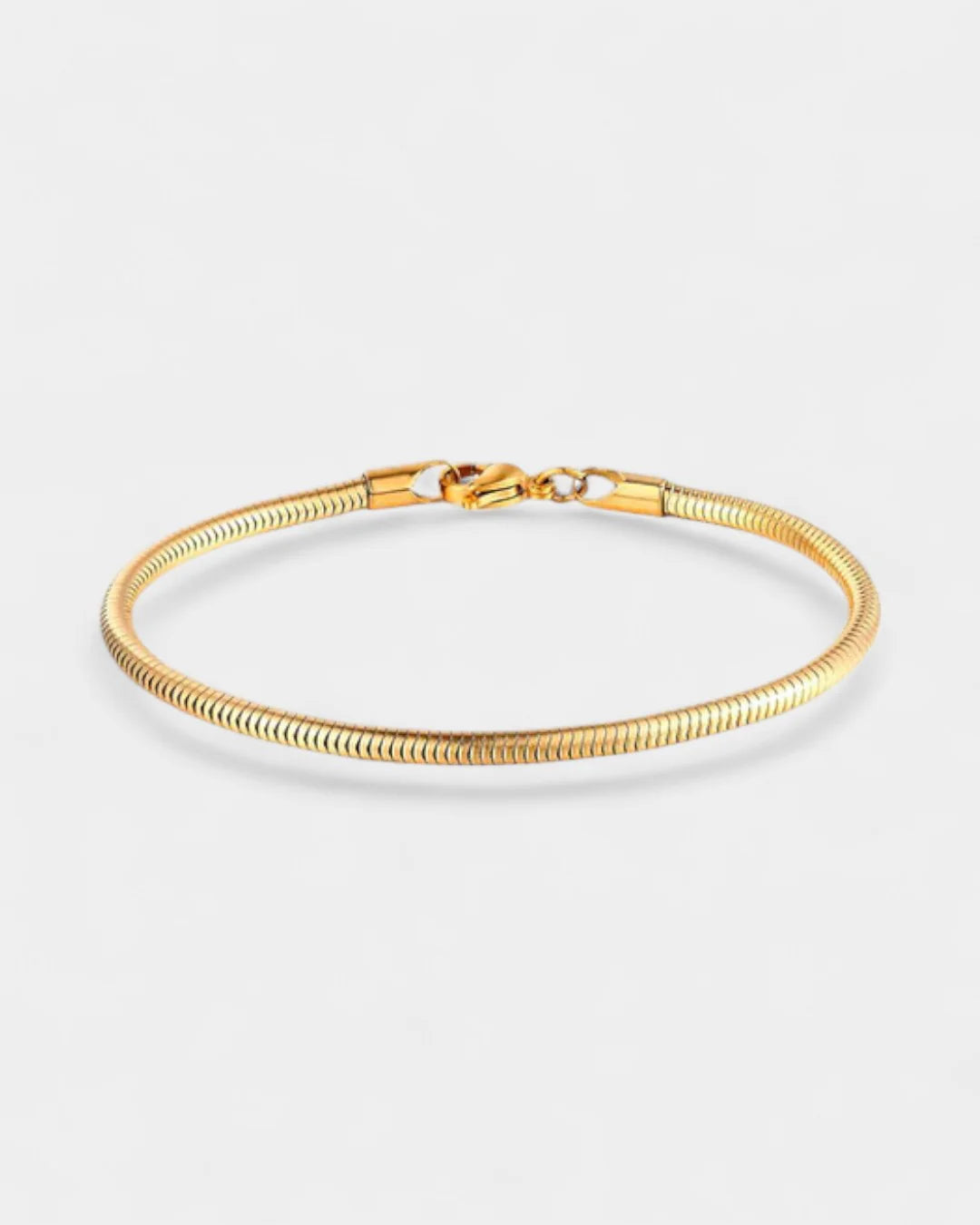 Gold bracelet on a light gray background